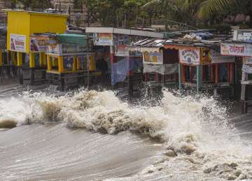 High waves crash against shops near the shore ahead of the landfall of Cyclone Biparjoy, in Mumbai
