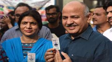  Manish Sisodia and his wife Seema Sisodia show their voter ID after voting at Pandav Nagar School on May 12, 2019.