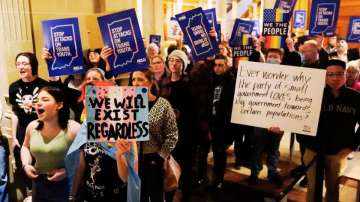  Protesters stand outside of the Senate chamber at the Indiana Statehouse 