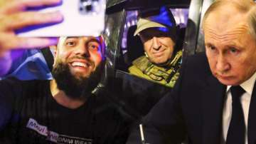 Wagner's chief Yevgeny Prigozhin, right, sits inside a military vehicle posing for a selfie photo with a local civilian on a street in Rostov-on-Don.