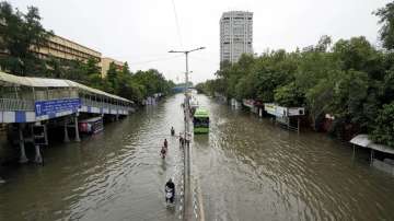 Commuters move through a waterlogged road at ITO, in New Delhi