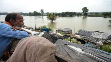 A flood-hit resident looks at houses submerged in the floodwaters of swollen Yamuna river near Nizamuddin Bridge