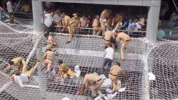 Mumbai: Police personnel pull back the farmers who jumped on the safety nets during a protest against low compensation for their land in the Mantralaya building, in Mumbai, Tuesday, Aug 29, 2023.