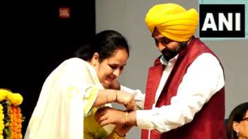 Punjab Chief Minister Bhagwant Mann as a woman ties him a rakhi