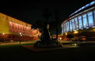 The old and new Parliament building is seen illuminated during the Monsoon session of Parliament, in New Delhi
