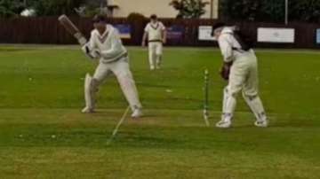 Alex Steele keeping wickets with an oxygen cylinder on his back