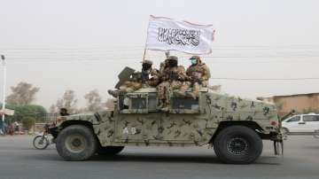 Taliban patrol on road during celebration marking second anniversary of withdrawal of US troops from Afghanistan