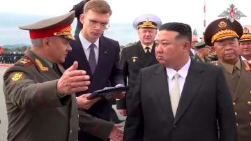 Kim Jong Un, right, listens to Russian Defense Minister Sergei Shoigu, left, as he inspects Russian warplanes at Vladivostok