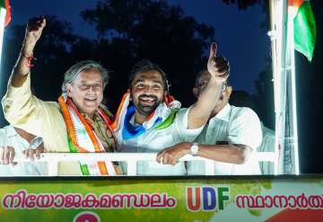 Congress MP Shashi Tharoor with party candidate and former Kerala CM Oommen Chandys son Chandy Oommen