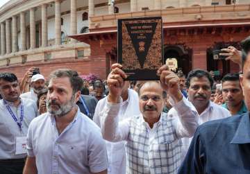 Congress MP Adhir Ranjan Chowdhury, holding the Constitution of India, with party MP Rahul Gandhi and other Parliamentarians walks towards the new Parliament building