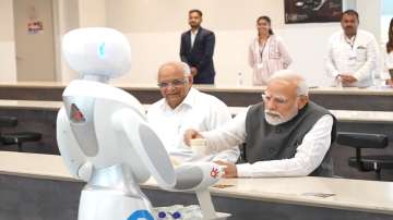 A robot serves tea to PM Modi and CM Bhupendra Patel