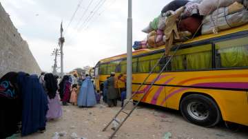 Afghan families board into bus to depart for their homeland, in Karachi