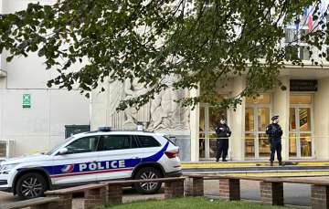 Police stand guard outside Gambetta-Carnot school, where a teacher was stabbed to death