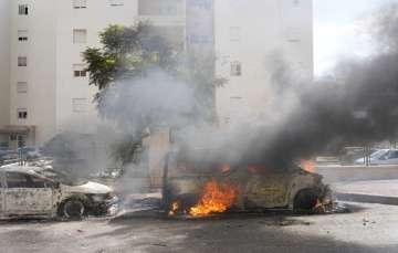 Cars set ablaze after Hamas launched a barrage of rockets targeting Israel.