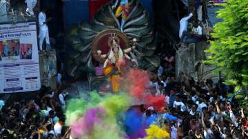 Devotees carry an idol of Goddess Durga to a puja pandal