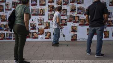 People look at photos of hostages that are being kept by Hamas.