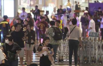 Tourists evacuating from Bangkok’s Siam Paragon Mall after gunfire was heard.
