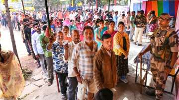 Voters wait in queues at a polling station to cast their votes for the Madhya Pradesh Assembly elections.