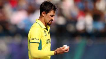 Mitchell Starc looks at the condition of the white Kookaburra.