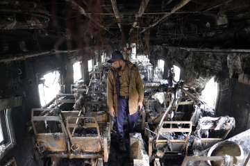 Bangladeshi firefighter checking the torched train.