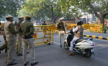 Police personnel check indentification card of a commuter near the Parliament House, 