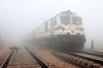 A train passes by amid fog on a cold winter morning, in Gurugram on Wednesday