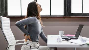 Woman suffering from backache at work
