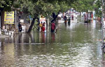 Locals wade through a waterlogged street after heavy rain, in Chennai.