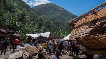 Congolese civilians gather after the death of their family members following rains that destroyed bu