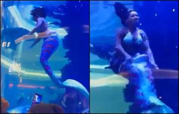 The 'mermaid's' tail got stuck inside the aquarium, as seen in the video.