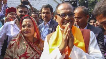 Madhya Pradesh Chief Minister Shivraj Singh Chouhan and wife Sadhna Singh greet BJP workers during counting of votes for MP Assembly elections, in Bhopal.