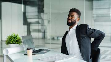 businessman office desk suffering from back pain 