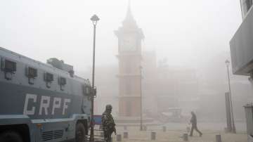 A security personnel stands guard at Lal Chowk amid dense fog, in Srinagar.