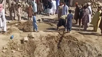 People gather near rubble in the aftermath of Pakistan's military strike on an Iranian village near 