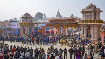 Security personnel stand guard to manage the crowd as they wait for darshan at the Ram temple, in Ayodhya.