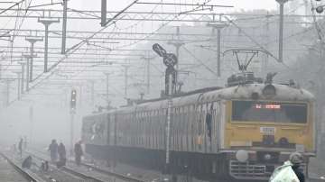 A local train runs on its tracks amid fog on a cold winter morning in Kolkata