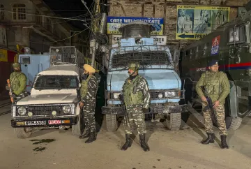 Security personnel stand guard during a cordon and search operation after terrorists shot dead a worker from Punjab while another sustained injuries in the Habba Kadal area