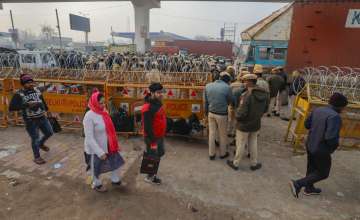 New Delhi: Commuters walk past barricades put up at Tikri border in view of farmers Delhi Chalo march, in New Delhi