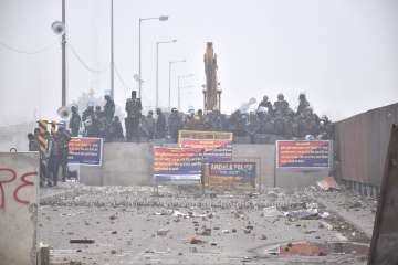 Security personnel stand guard behind a roadblock during the farmers protest over various demands, including a legal guarantee of minimum support price (MSP) for crops, at the Punjab-Haryana Shambhu Border