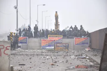 Security personnel stand guard behind a roadblock during the farmers protest over various demands, including a legal guarantee of minimum support price (MSP) for crops, at the Punjab-Haryana Shambhu Border