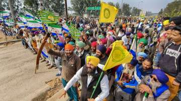 Farmers hold flags and raise slogans during their ongoing protest over various demands, including a legal guarantee of minimum support price (MSP) for crops, at the Punjab-Haryana Shambhu Border.