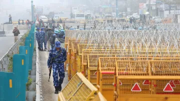 Police and security personnel keep a vigil near multi-layered barricading ahead of the protesting farmers’ ‘Delhi Chalo’ March, at the Singhu Border, in New Delhi.