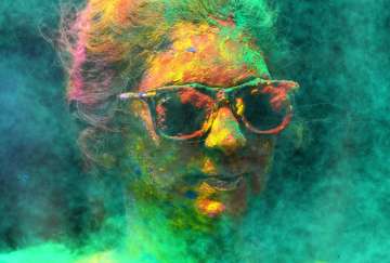 A woman smeared with colours celebrates Holi, the Hindu festival of colours, in Mumbai