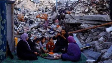 Palestinians break their fast amid the rubble of their destroyed home during the Muslim holy fasting