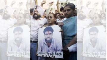 Family members of Sarabjit Singh hold his picture in Amritsar on June 25, 2009