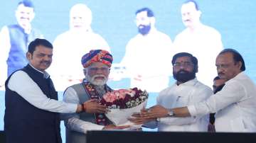 PM Modi being felicitated by Maharashtra Chief Minister Eknath Shinde and the Deputy Chief Ministers Devendra Fadnavis and Ajit Pawar during a public event.
