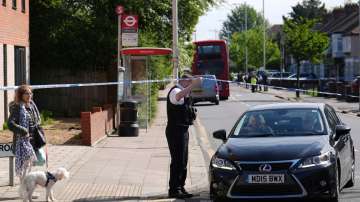 Police talking to members of the public at the scene in Hainault, north east London, Tuesday, April 