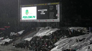 Spectators trying to avoid the heavy downpour at the Rawalpindi Cricket Stadium. 