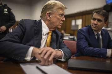 Former President Donald Trump sits in a courtroom next to his lawyer Todd Blanche before the start o