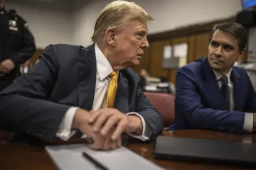 Former President Donald Trump sits in a courtroom next to his lawyer Todd Blanche before the start o